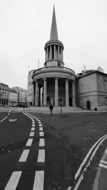 A black and white photograph of the historic St. Martin-in-the-Fields church in Trafalgar Square, London, showing its prominent circular portico with classical columns supporting a dome-shaped structu